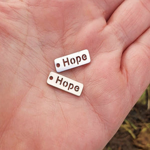 Berlock med text "Hope" i rostfritt stål